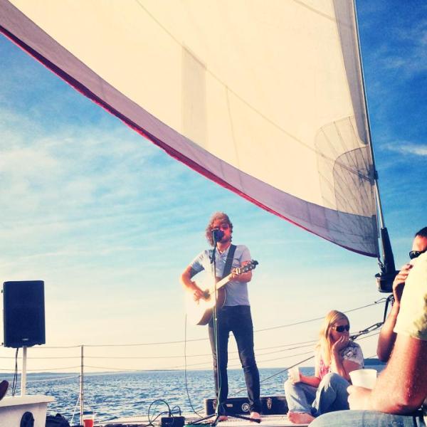 A musician playing to an audience on the Nauti-Cat
