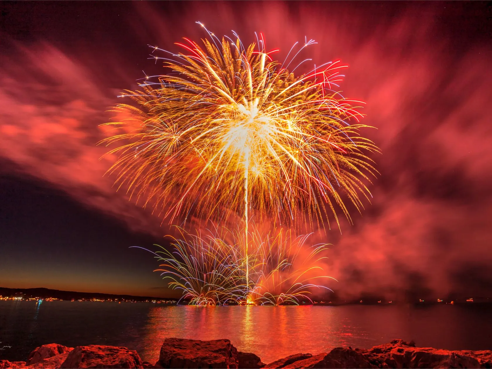 fireworks in the sky over a body of water